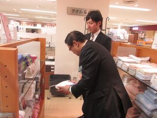 市長が商品のタオルを手に取って見ている写真