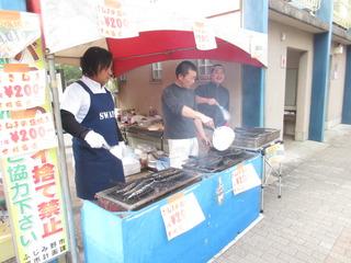 出店でさんまを焼いているお店の人3人を写した写真