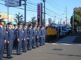 道路脇に一列で並ぶ警察官の人達を右斜め前から写した写真