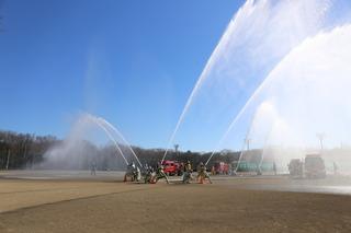 消防出初式にて放水演習が行われている写真