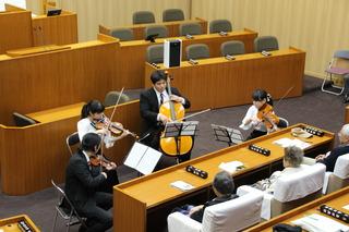 新春議場コンサートにてバイオリンなどの弦楽器の演奏が行われている写真