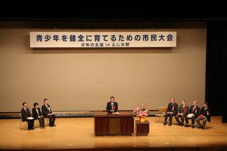 青少年を健全に育てるための市民大会で、演台に立ち話をする市長の写真