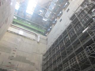 鉄の足場が組まれている環境センターの下から天井が映る写真