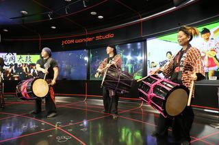 番組スタジオで、福岡太鼓をたたく3名の男女の写真