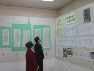 上福岡歴史民俗資料館友の会作品展示会で、作品を見ている市長と女性の写真