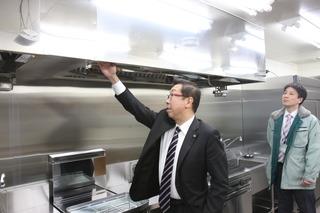 本庁舎地下の調理場の換気扇を触っている市長の写真