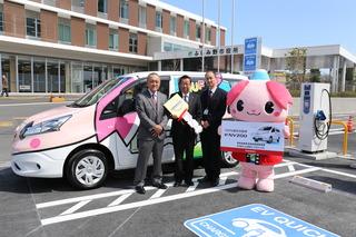 電気自動車の前で、大きなカギを持つ市長と関係者、ふじみんが並んでいる写真