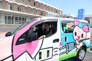 ふじみんを車体にラッピングした電気自動車に乗る、市長と男性の写真
