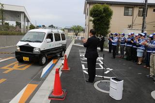 青色防犯パトカー市民パトロール隊出発式でパトロール車の出発を市長と青い帽子に青いベストを着用した隊員たちが拍手している写真