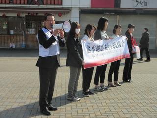 街頭でスピーカーマイクを持った市長と横断幕を掲げている職員、募金箱を首に下げた職員たちが熊本地震義援金募金を呼びかけている写真