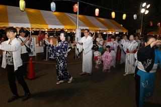 浴衣を着て盆踊りを踊っている市長と市民の皆様の写真