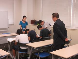 寺子屋中学生コースで授業を受けている3人の中学生の様子を後ろから見ている市長の写真