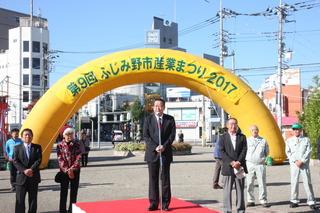 第9回ふじみ野市産業まつり2017と書かれた門の前で挨拶をしている市長の写真