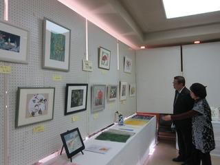 「絵画」の展示ブースで女性に案内を受けている市長の写真