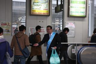 駅でティッシュを配りながら市民に呼びかけをしている市長の写真