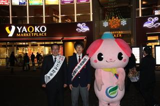 冬の交通事故防止運動で、暗くなった街頭にて七井 翔哉さんと市長が肩からタスキをかけて、ふじみんと一緒に写っている写真
