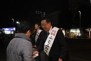 七井 翔哉さんと市長が街頭で、市民の方にチラシを手渡ししている写真