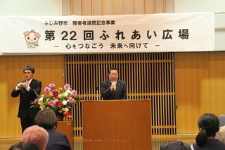 「第22回 ふれあい広場」と書かれている横断幕の前で市長が壇上に立って話をしている写真