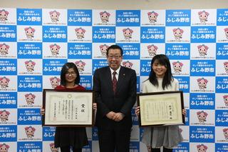 神木 琴音さん、新井 蓮花さんが、額縁に入った表彰状を手に持って市長と一緒に笑顔で写っている写真