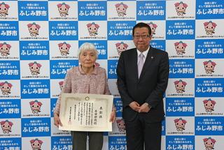原田 静穂さんが表彰状を手に持って、市長と一緒に写っている写真