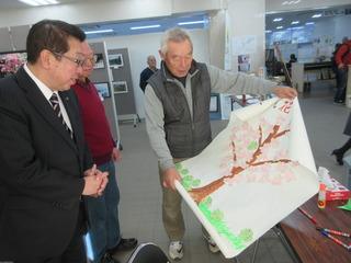 桜の花が描かれた「絵」を広げ見ている市長の写真