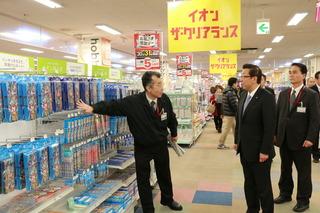 イオン大井店の文具売場の前で、市長がお店の関係者の男性から説明を受けている写真