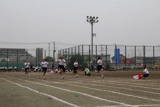 徒競走が行われており、女子生徒の1組がゴールに向かって走ってくる様子の写真