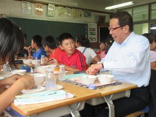グループごとに給食を頂いており、市長も子ども達のグループに加わって楽しそうに給食を食べている写真