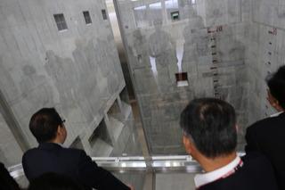 工場内のコンクリートで作られている焼却炉を上層階から市長と関係者の方々が見学している写真