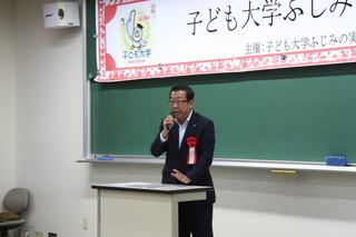 「子ども大学ふじみの」の入学式で教壇にて市長がマイクを持って話をしている写真