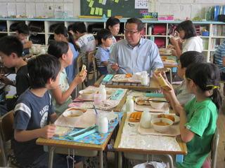 グループに分かれて給食を食べており、市長も子ども達のグループに入って楽しそうに給食を食べている様子の写真