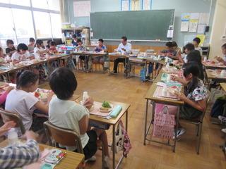 給食の時間に市長が教室の子ども達の輪の中に入って、みんなの顔を見ながら、楽しい雰囲気で給食を食べている写真