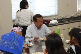市長が子ども達の同じテーブルにの席に着いて出来上がった料理を一緒に話ながら食べている写真