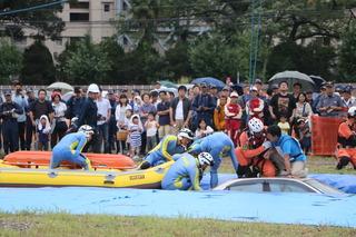 水没した車から人を助け出す訓練が行われており、その様子を沢山の人が見ている様子の写真