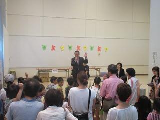 市長が親子連れの参加者の前で、左手を挙げてマイクを持って笑顔で話をしている写真