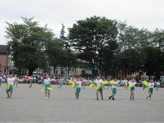 児童達が、グランドに広がって、黄色い扇子を両手で持ってダンスをしている写真 市内小学校運動会（東台小）