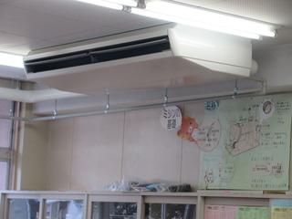 中学校の教室の天井に設置された大きな白いエアコンの写真