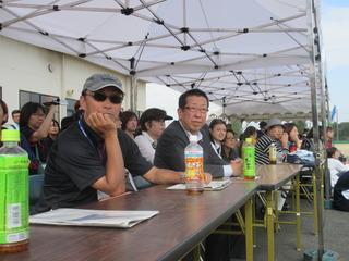 来賓席に座っている来場客と市長が、競技に見入っている様子の写真