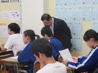 授業中に市長が生徒の座っている机の横に立ち、生徒のノートを覗き込でいる写真
