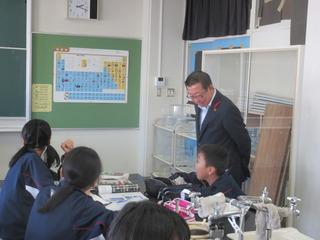 授業中に市長が子ども達の座っている机の後ろに立って子ども達の様子を見ている写真
