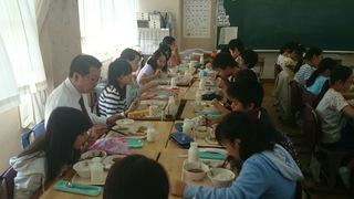 机を向かい合わせに並べて、市長も子ども達の中に入って、一緒に給食を食べている写真