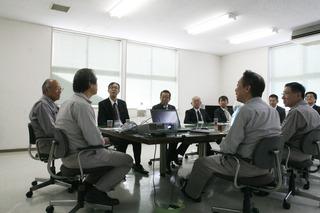 会議室にて、市長と工場の方や関係者の方々が席に着いて話をしている写真