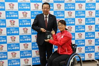 市長と車椅子の平澤奈古選手が盾のようなものを持って写っている写真