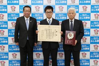 内田 保太郎さんが賞状を手に持って、関係の男性が優勝盾を持って、市長と3人で写っている写真