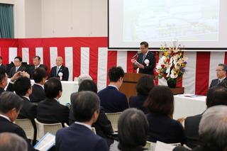 紅白の横断幕の前で市長が講壇に立って話しをしている写真