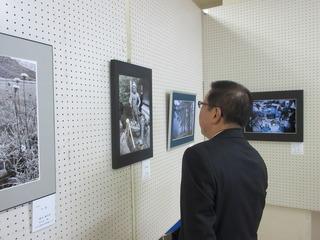 写真の作品が展示されており、市長が見ている写真