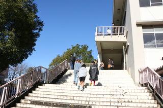 校舎に上がる階段を数名の方が昇っており、その姿を下から写している写真