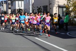 ロードレース大会がスタートして、選手達が一斉に沿道を走っている様子の写真