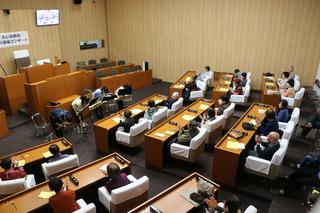 議場にてサックスの演奏者たちが礼をしており、観客が拍手している写真