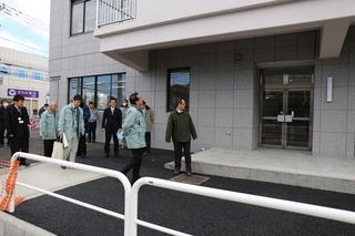 新しい第2庁舎の入り口から全体を見学している市長と職員達の写真